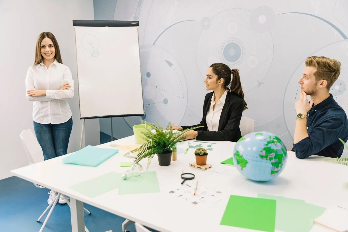 Geschäftspartner blicken auf eine Managerin, die mit gefalteten Händen in der Nähe eines Flipcharts steht.